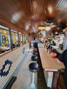 Frank's Diner on the inside with circle bar stools and the cozy interior of the train car diner